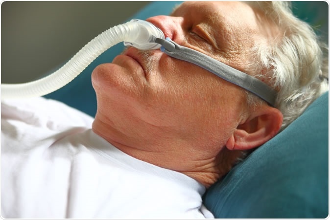 Male with breathing apparatus for sleep apnea.  Image Credit: Alice Day / Shutterstock