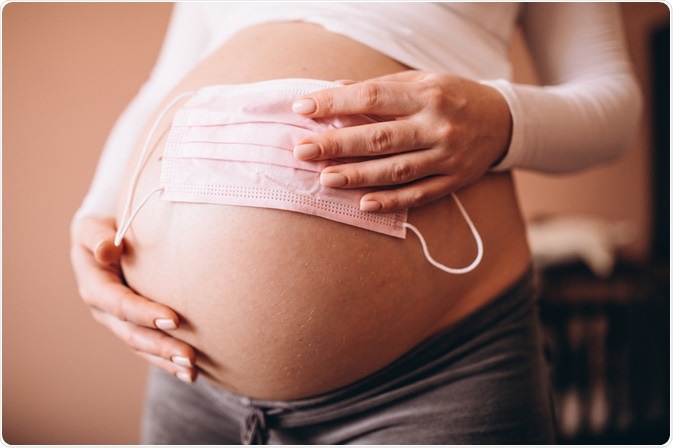 Pregnant Women holding Face Mask