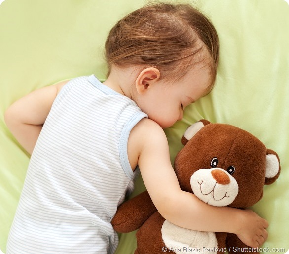 Sweet child sleeping with teddy bear