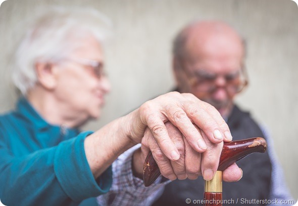 old couple. old man an woman still together holding each other hands over the man cane