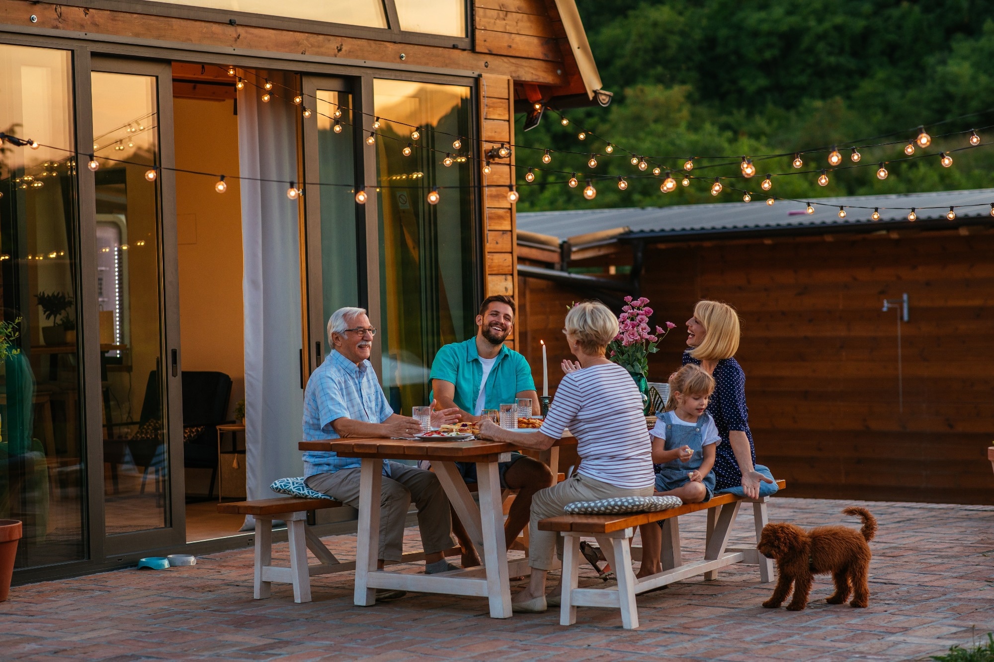 Happy family eating together outdoors. Smiling generation family sitting at dining table during dinner.