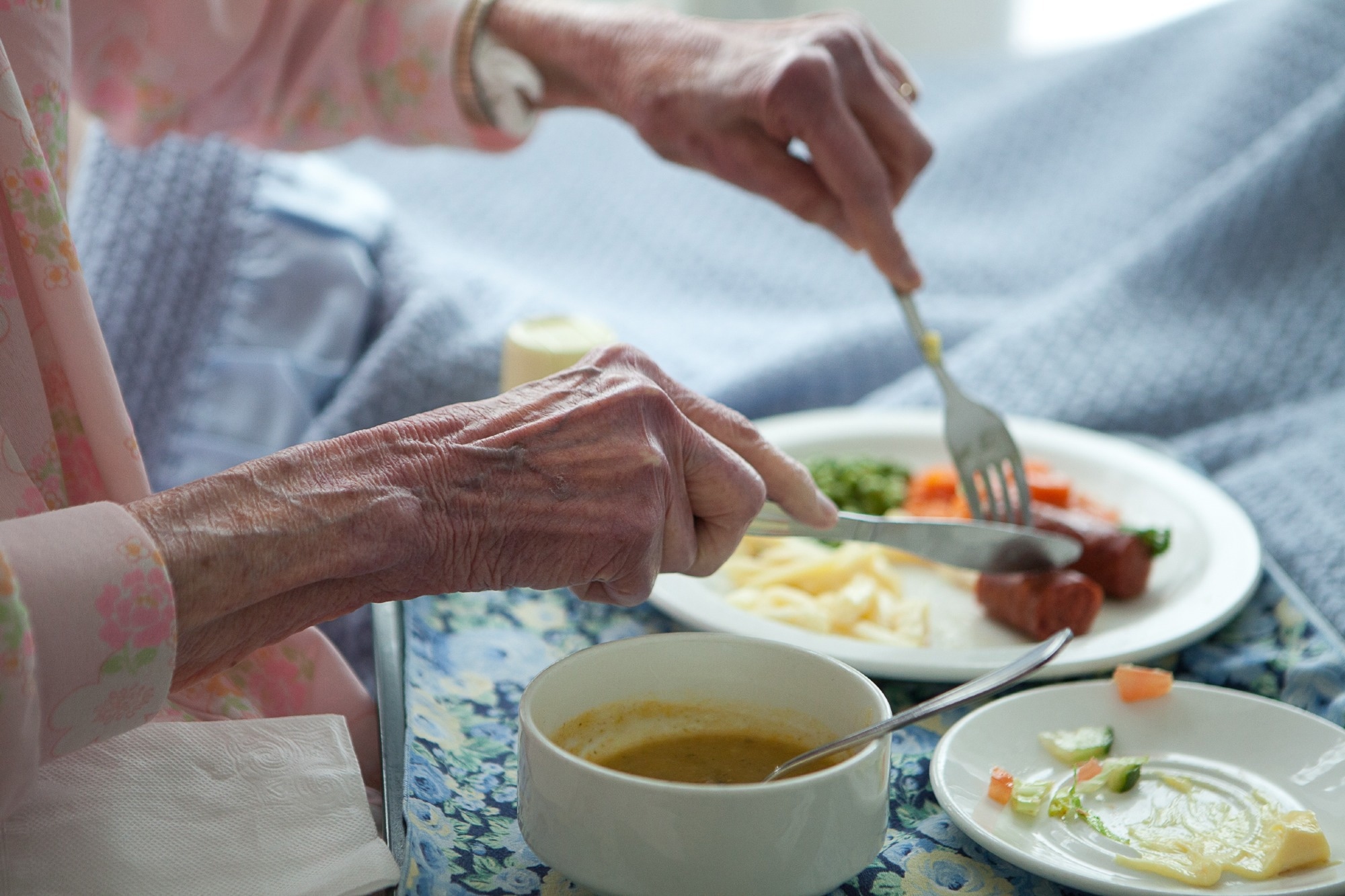Elderly lady eating healthy lunch in bed.