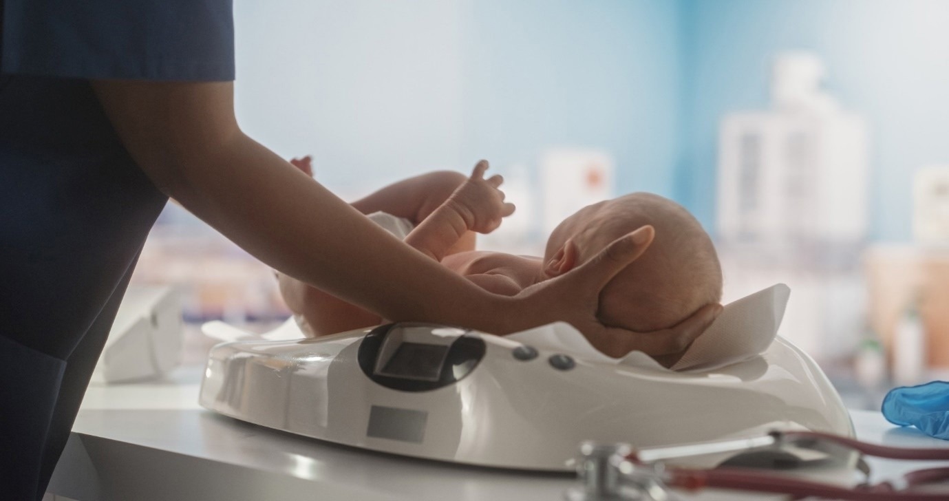 Newborn placed on weighing scales