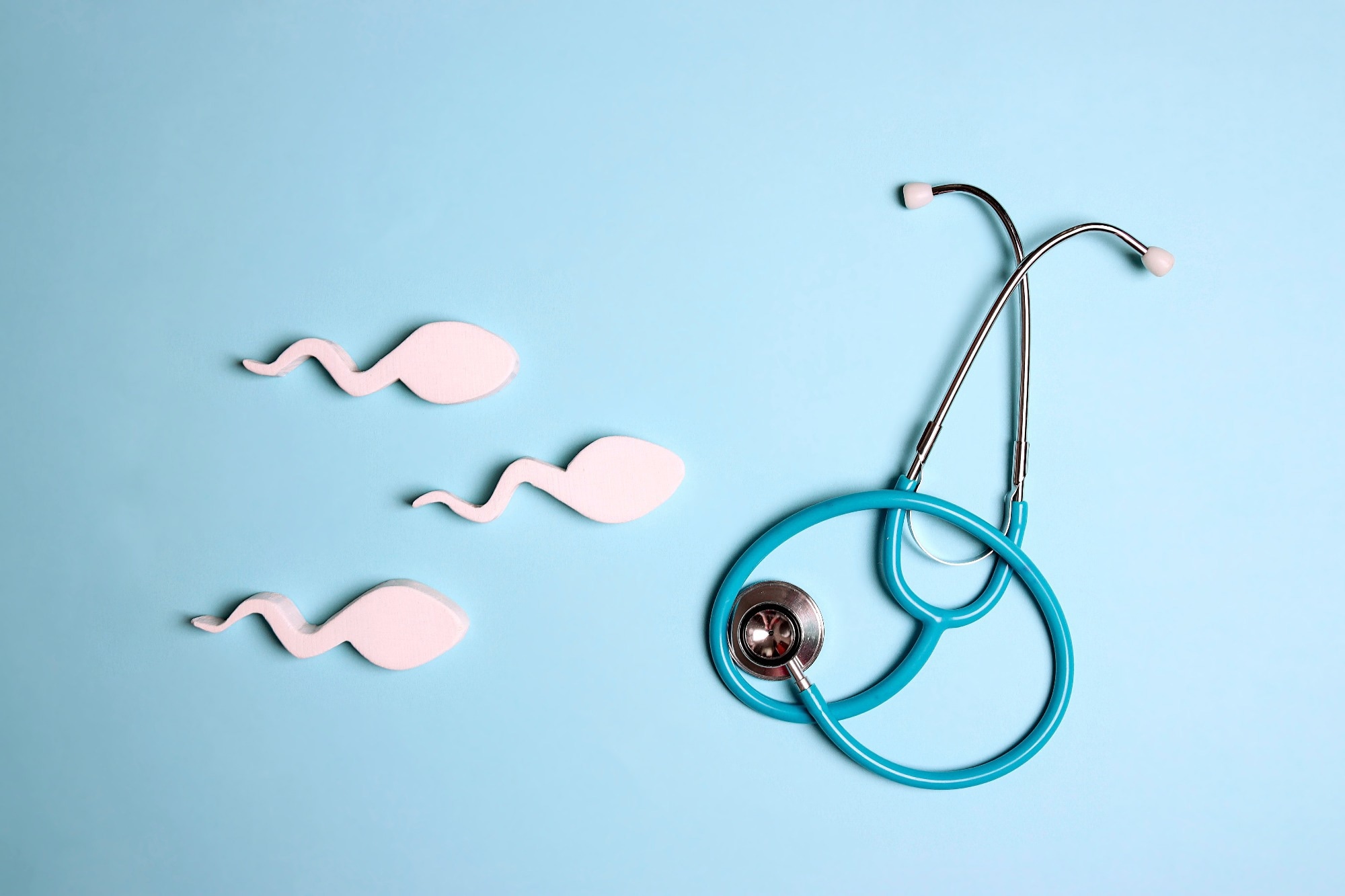 Sperm cells with stethoscope on blue background. Male sexual health.